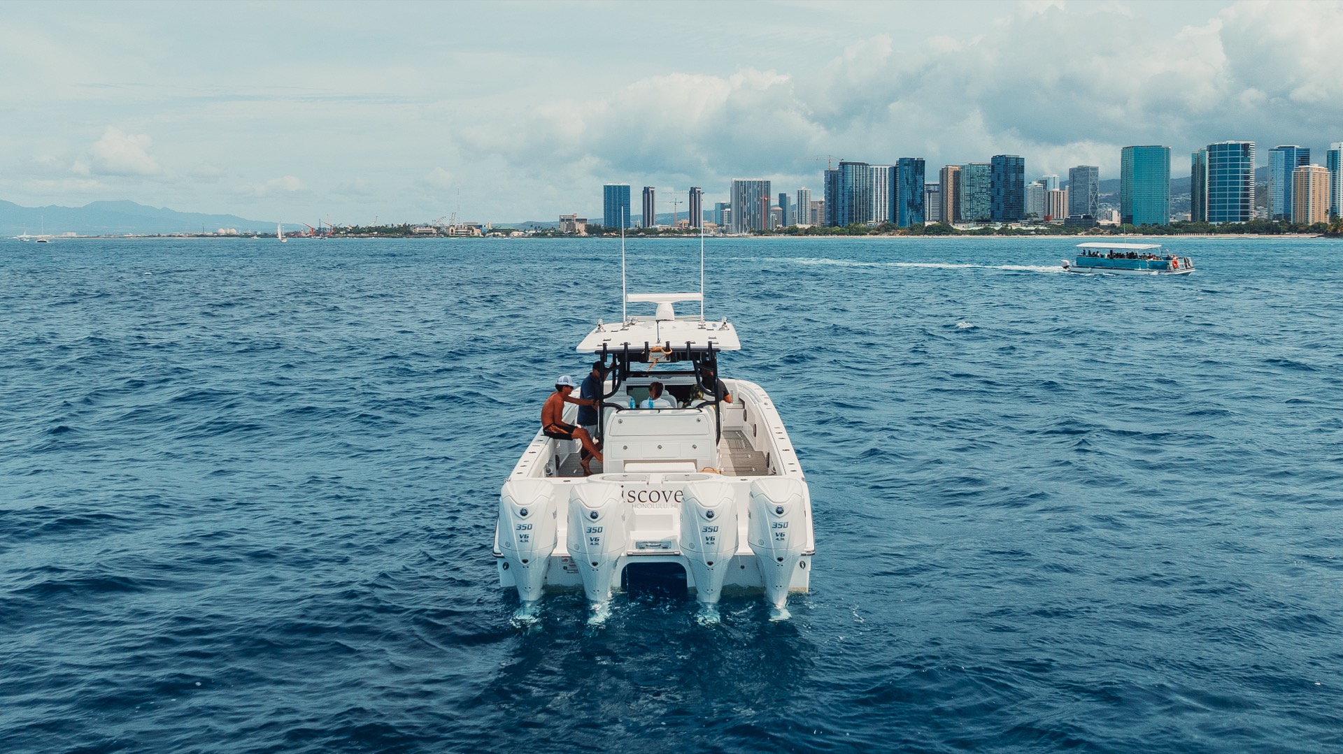 Aerial drone shot of a luxury yacht cruising on vibrant blue ocean water.