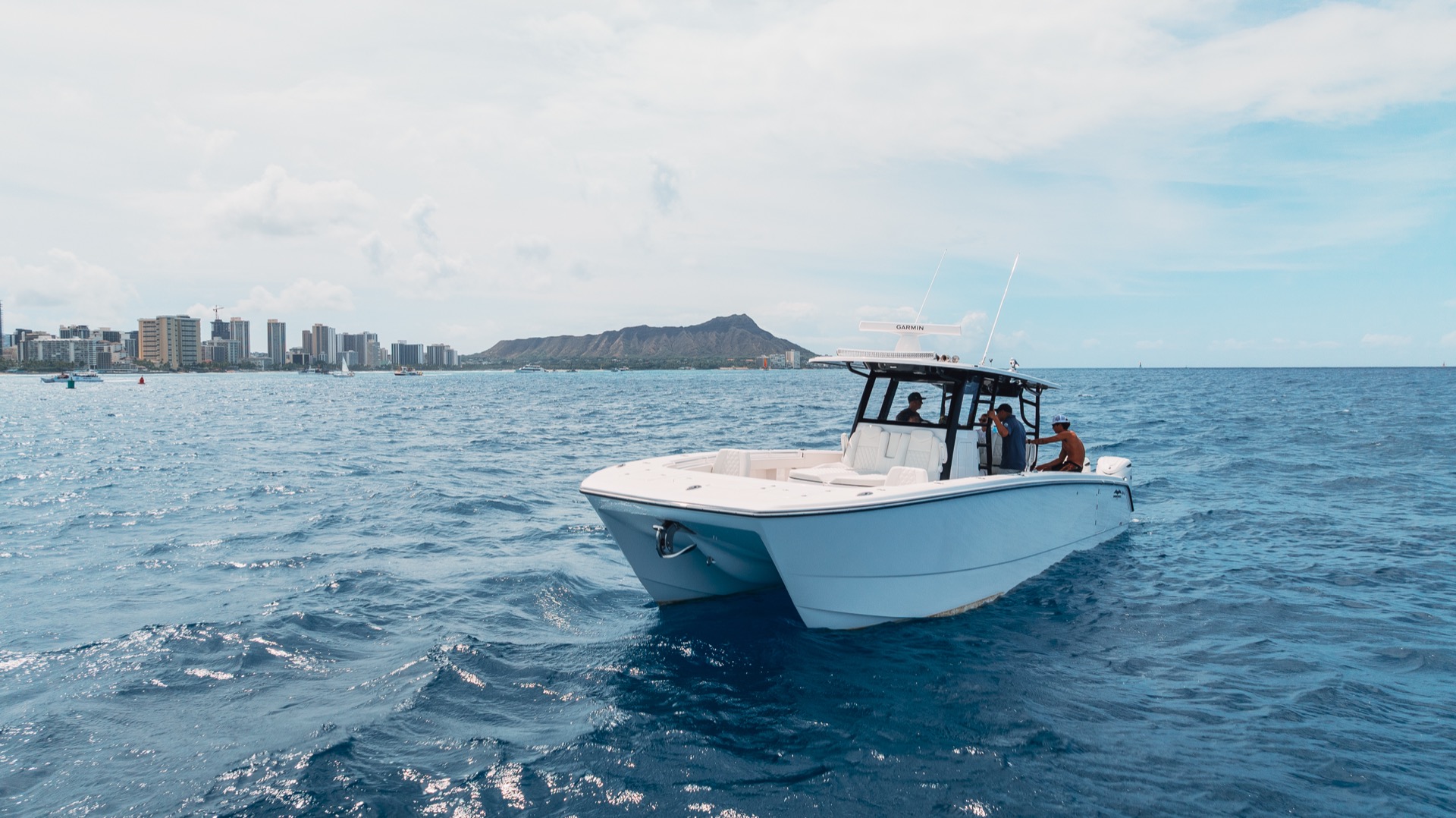 Aerial drone view of a luxury yacht cruising in clear blue ocean waters.